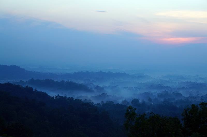 Candi Borobudur terlihat samar dikelilingi kabut tipis dari Punthuk Setumbu.